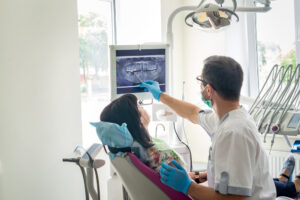 dentist showing patient's teeth on X-ray